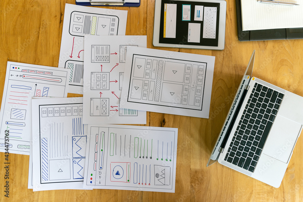 Fototapeta premium Top view of Creative flat lay UX designer working space and office supplies. Smartphone and tablet application layout prototype project.