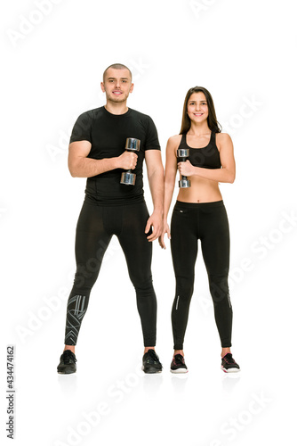 Full photo of fit athletic couple lifting dumbbells on white background