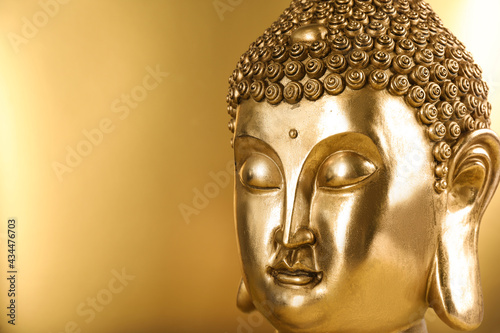 Buddha statue on golden background, closeup. Space for text © New Africa
