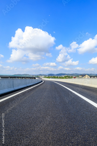 Country highway and blue sky with white clouds.