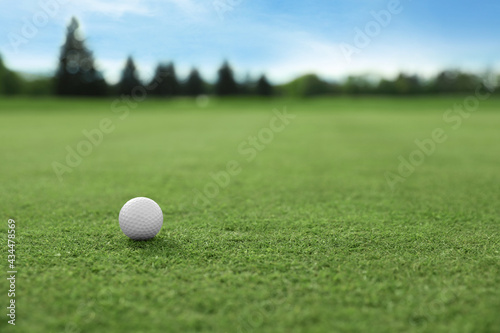 Golf ball on green course, space for text