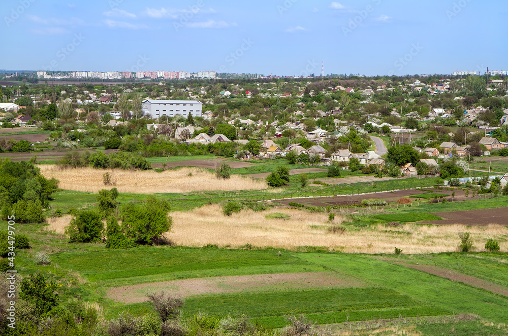 Panorama of fields and a small settlement, taken from the mountain. Landscape of the east of Ukraine in the spring. 