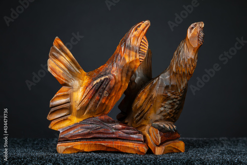 Figurines of wood grouse and black grouse birds carved from wood. Old wooden crafts on a dark background. 