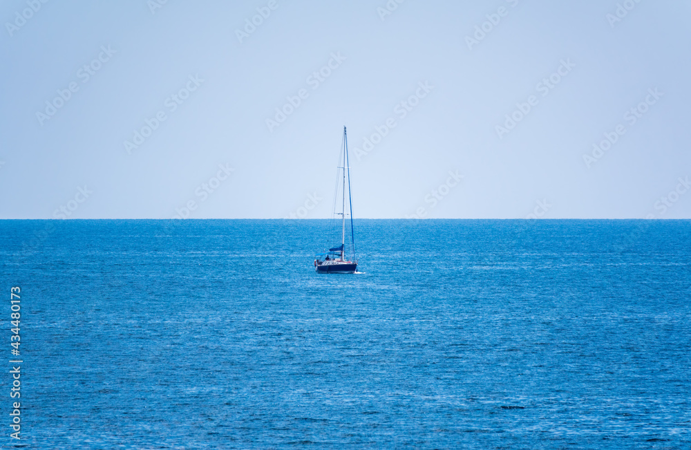 Sailing yacht in the blue calm sea.