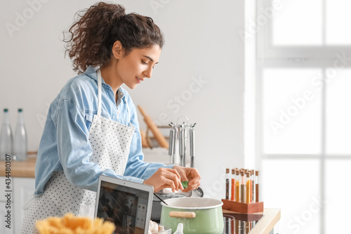 Young woman cooking in kitchen