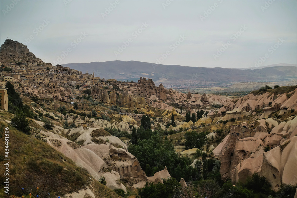The amazing landscape of Cappadocia. Unusual rocks with folded slopes, sharp peaks, caves. Rural houses on the mountainside. Pigeon Valley. Turkey