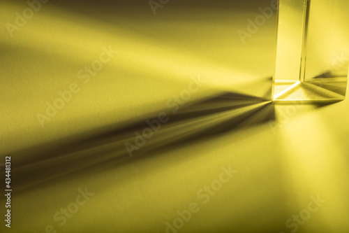 Colorful light play with a prism, made with colored strobe light on white sheet of paper. Painting with yellow light.