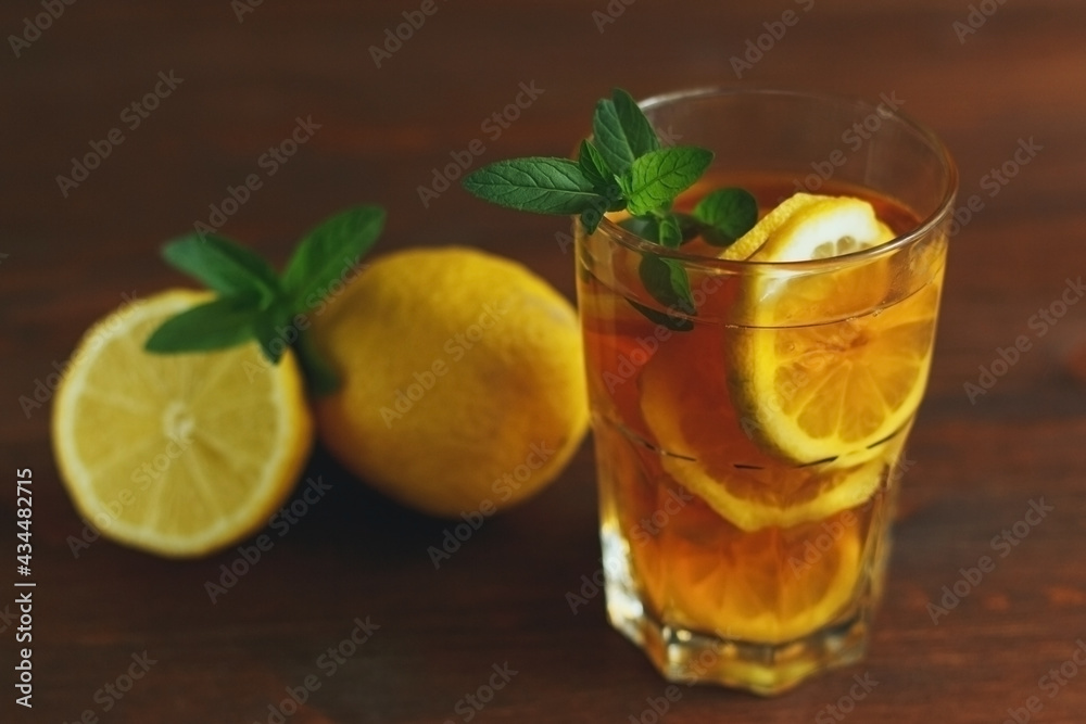 glass of ice lemon tea with mint on a wooden background. Homemade Summer drink. With copy space glass of ice lemon tea with mint on a wooden background. Homemade Summer drink. With copy space