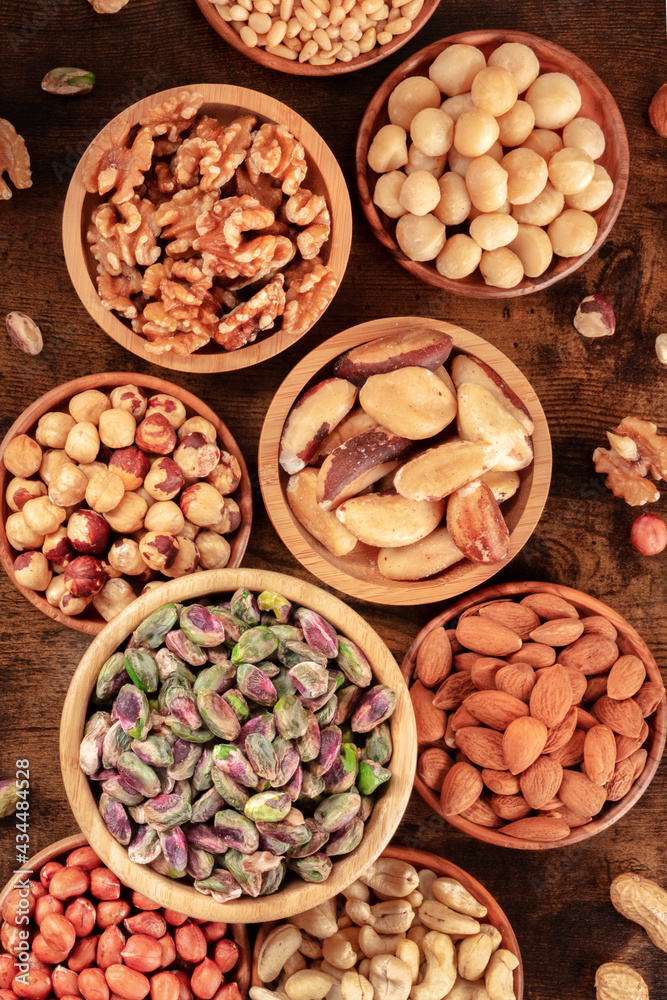 Nuts in wooden bowls, shot from above on a rustic wooden table