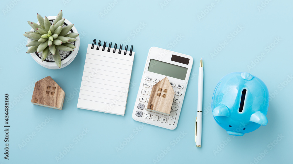 Housing finance concept, calculator with house model and piggy bank Housing finance concept, calculator with house model and piggy bank
