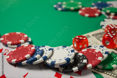 Classic playing cards, chips, red dice and dollars on green background. Gambling and casino concept.