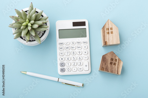 Calculator with house model, home loan or mortgage concept photo