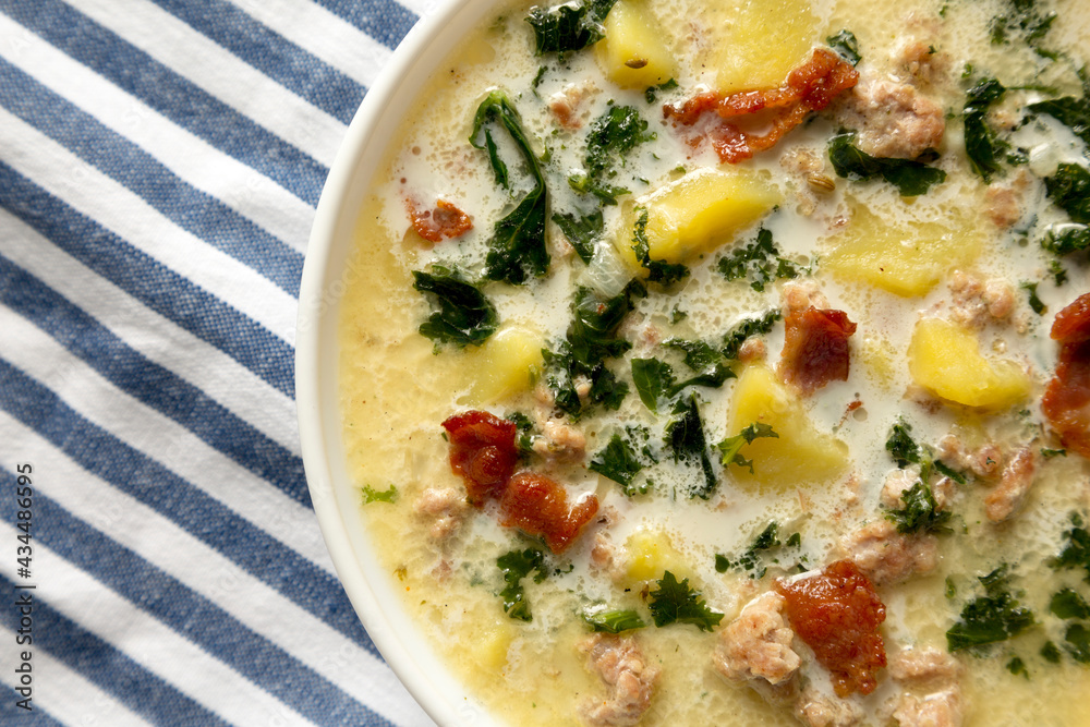 Homemade Zuppa Toscana with Kale and Bread in a white bowl, top view. Flat lay, overhead, from above. Close-up. Homemade Zuppa Toscana with Kale and Bread in a white bowl, top view. Flat lay, overhead, from above. Close-up.