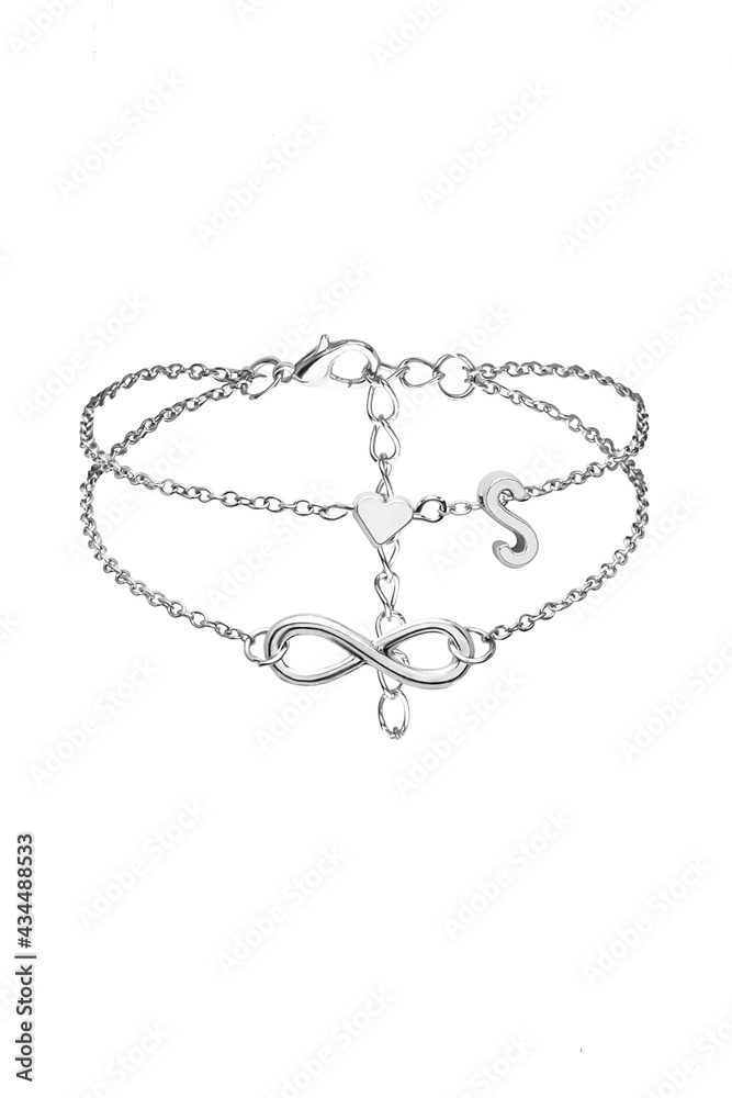 Detail shot of silver anklet made as double-row chain with charms shaped as infinity sign, heart and letter S. The elegant foot bracelet with lobster clasp is isolated on the white background. Detail shot of silver anklet made as double-row chain with charms shaped as infinity sign, heart and letter S. The elegant foot bracelet with lobster clasp is isolated on the white background.