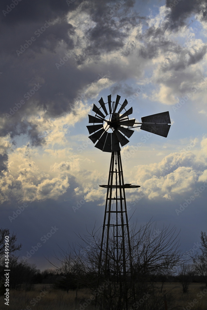 Kansas colorful Sunset with clouds and a Windmill silhouette north of Hutchinson Kansas USA out in the country. Kansas colorful Sunset with clouds and a Windmill silhouette north of Hutchinson Kansas USA out in the country.