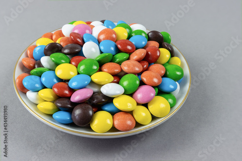 Round milk chocolate balls on a plate on a brown background