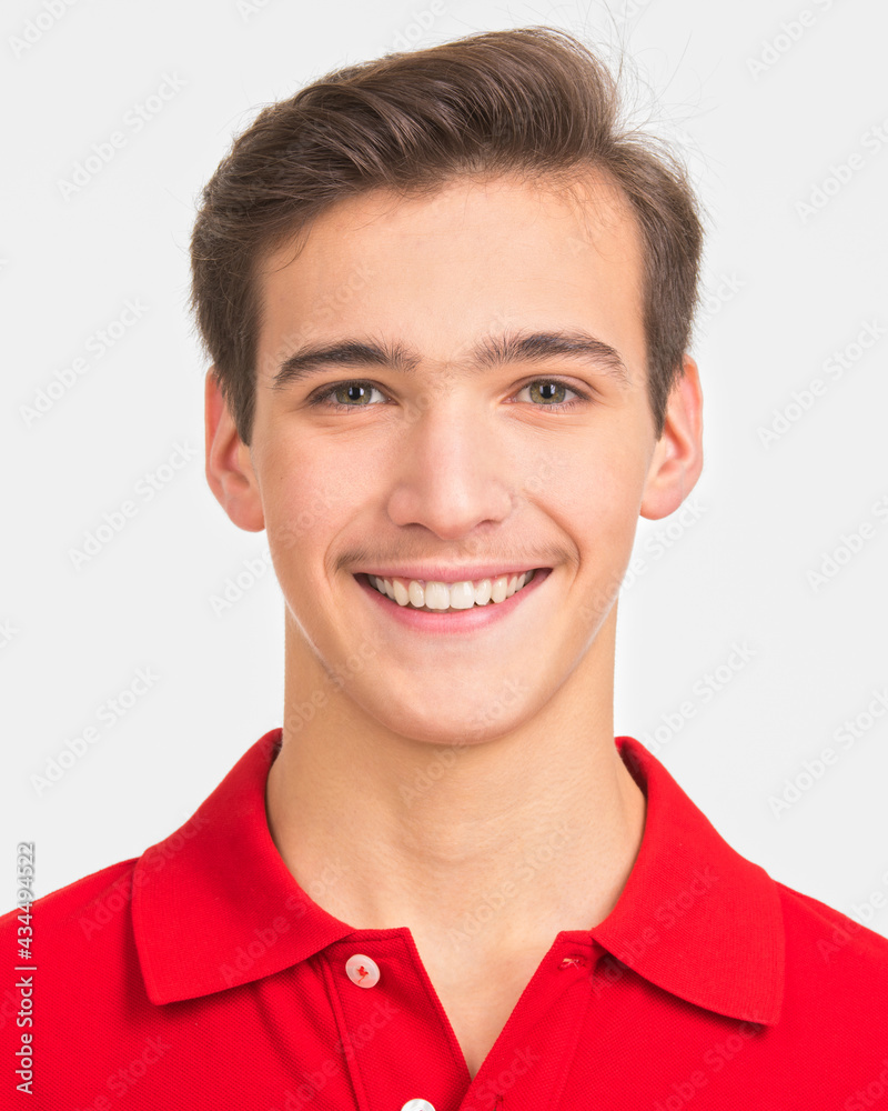 Photo of young happy man looking at camera. Closeup Portrait of smiling handsome guy posing at studio. Attractive male face with a smile. Teenager in a red shirt. Human face with a healthy teeth. Photo of young happy man looking at camera. Closeup Portrait of smiling handsome guy posing at studio. Attractive male face with a smile. Teenager in a red shirt. Human face with a healthy teeth.