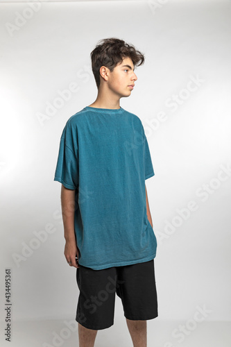 Portrait of teenager on white background in studio. The boy is standing