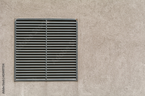 Metal ventilation outlet on a house wall with air slits. Wall background with copy space for text