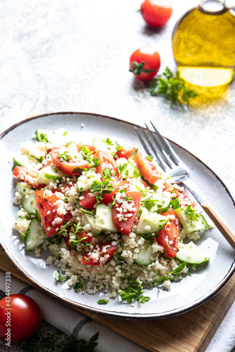 Traditional oriental salad Tabouleh. Tabule cous cous salad with vegetables. Tabbouleh with bulgur