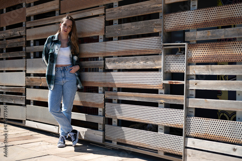 Young casual style girl posing on a wall