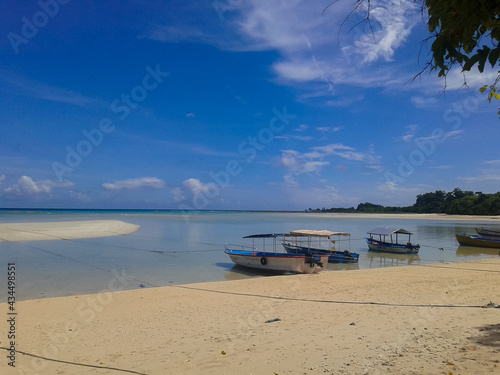Boats docked near the sandy beach   Boat parked at the island © Rupan