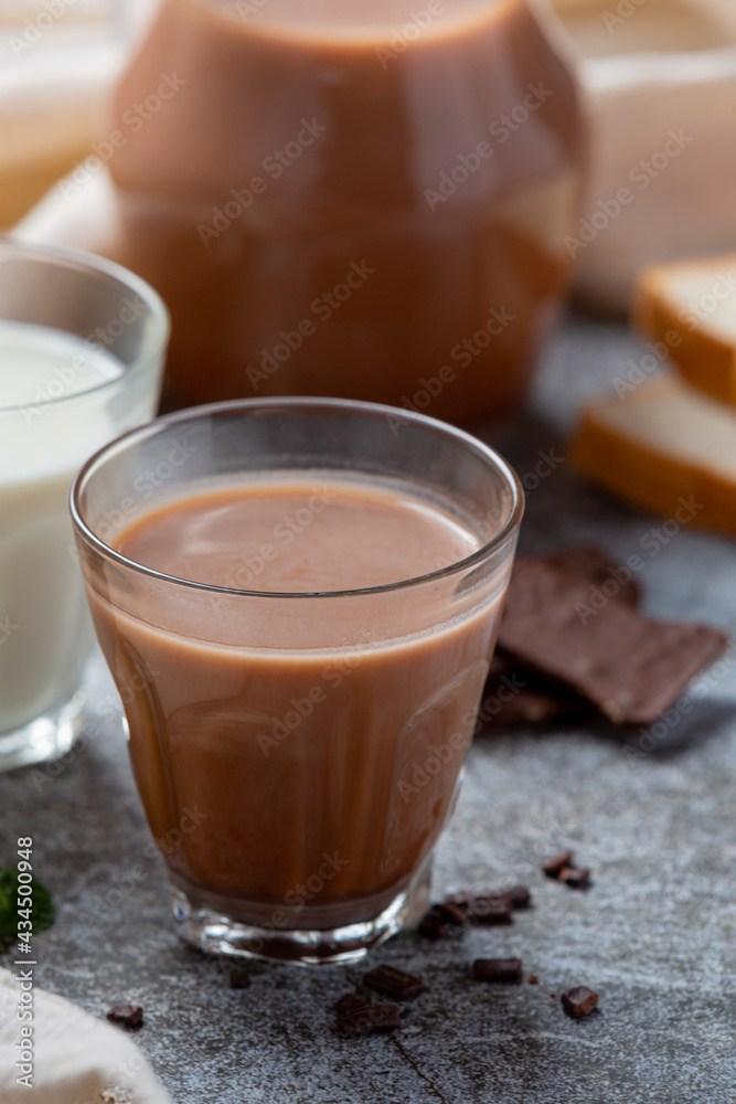 Glass of chocolate milk on the dark background.