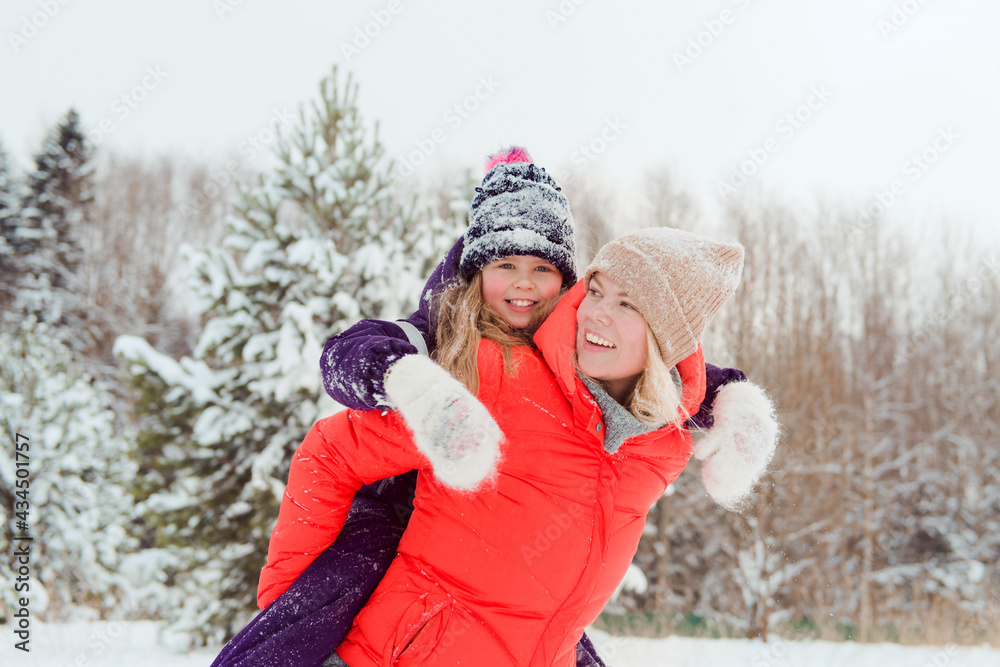 mother Carrying daughter Piggyback Having Fun In Winter Forest