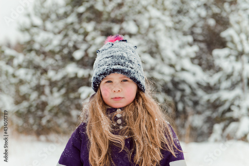 Girl in snowy hat outdoors winter trees background