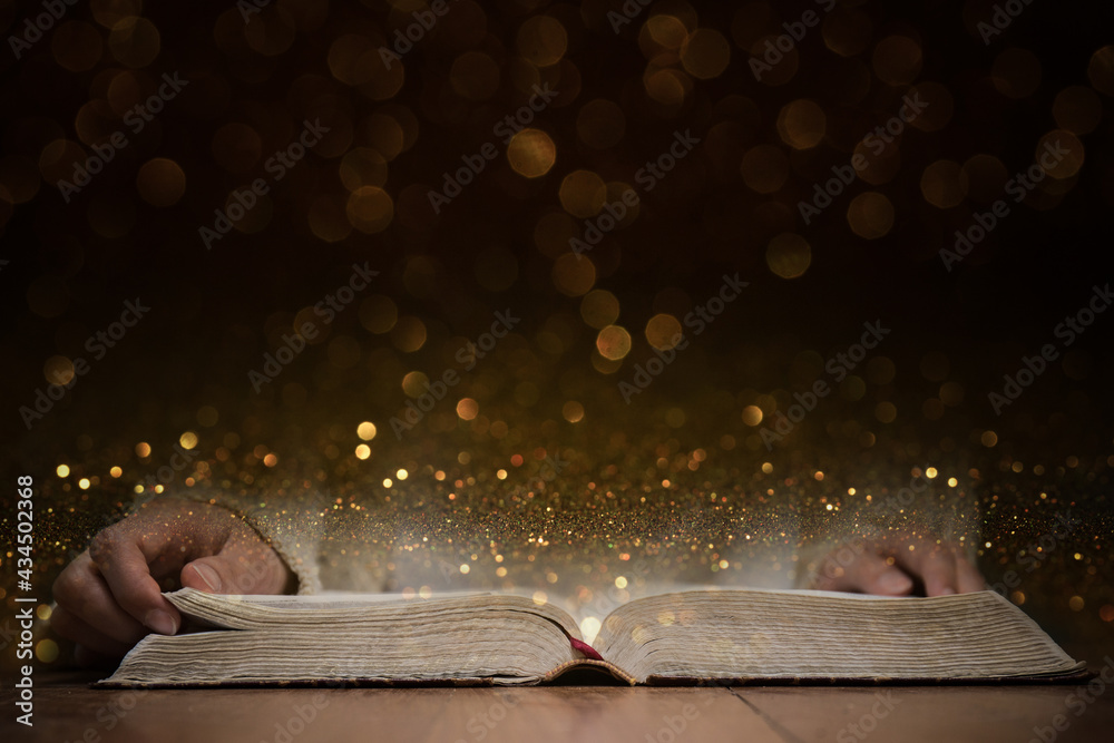 A person reading a Holy Bible with gold background.  - obrazy, fototapety, plakaty 