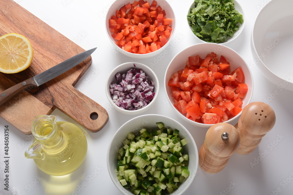 White bowls with grated vegetables of different colors. Cooking board with Ingredients ready for the salad. White bowls with grated vegetables of different colors. Cooking board with Ingredients ready for the salad.