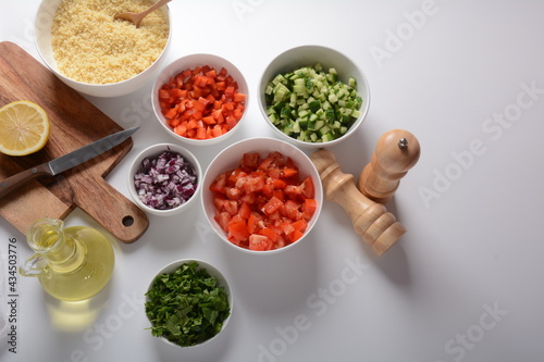 White bowls with grated vegetables of different colors. Cooking board with Ingredients ready for the salad.