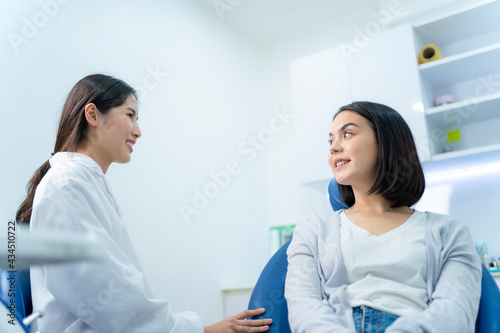 Caucasian female patient consulting dentist for oral care treatment.