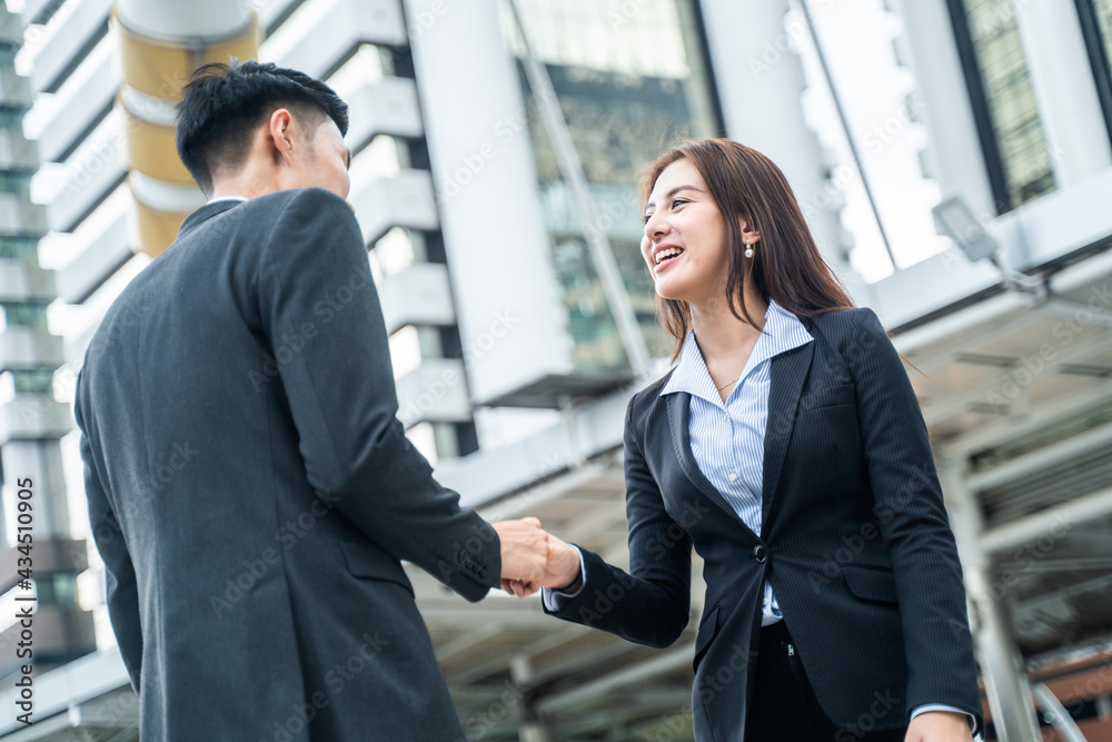 Asian business people greeting by making handshake outdoor in the city