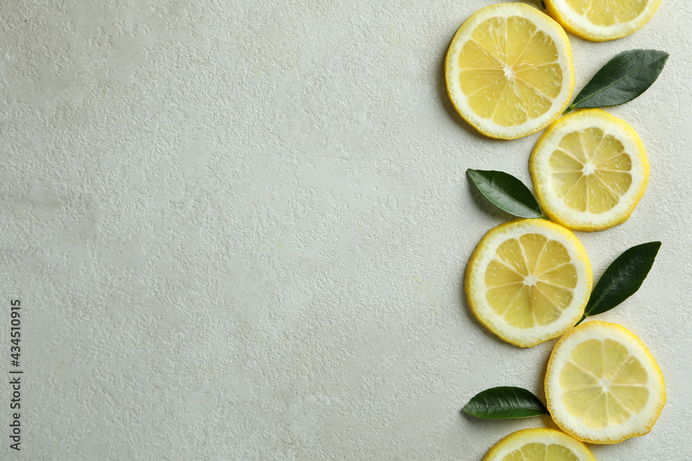 Lemon slices and leaves on white textured background, space for text Lemon slices and leaves on white textured background, space for text