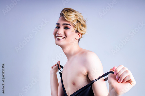 asian man with luxurious blonde hair and gorgeous make-up in white wall studio background happy smile look at camera