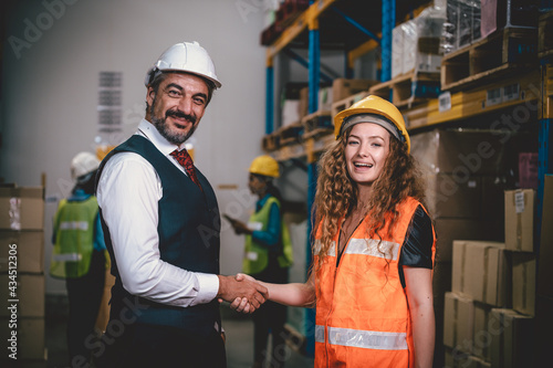 Portrait woman workers and engineer posing under show hand cooperated teamwork successful project in factory warehouse.