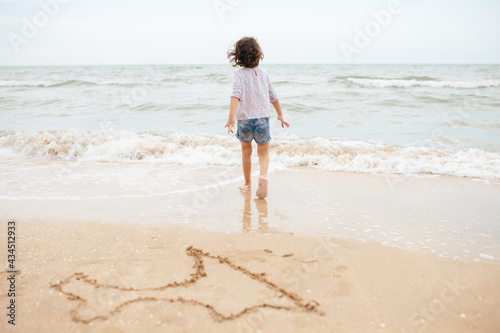 Five years cute curlyFive years cute curly caucasian girl painting on sand on the beach.  © sweetlaniko