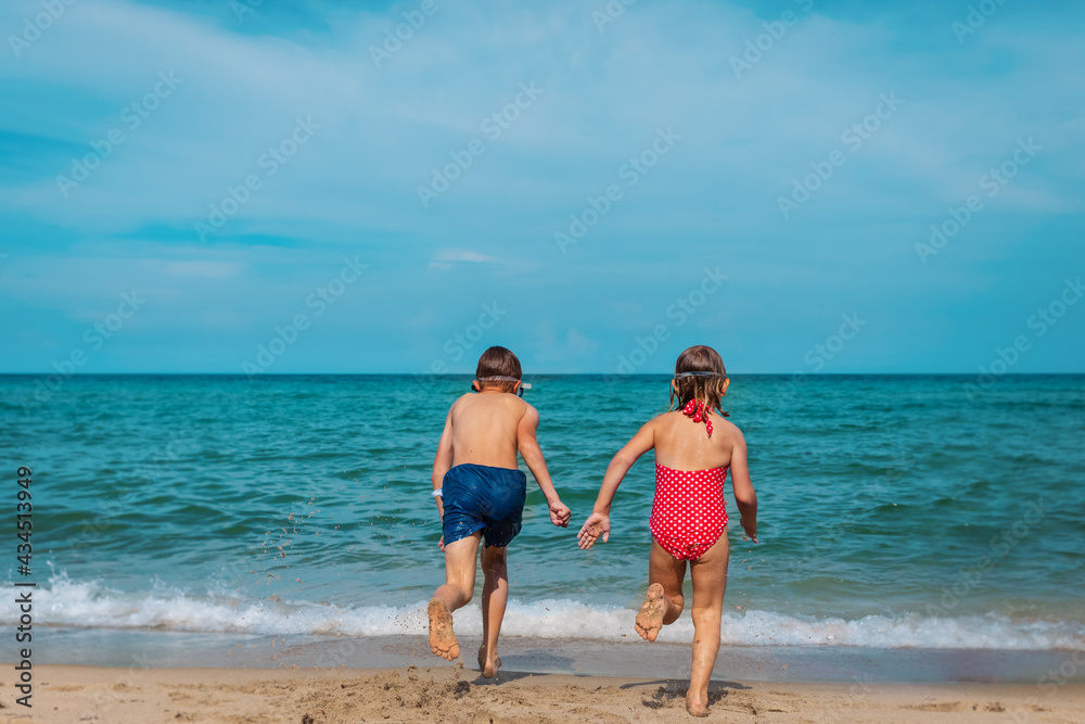 kids run to swim on tropical beach