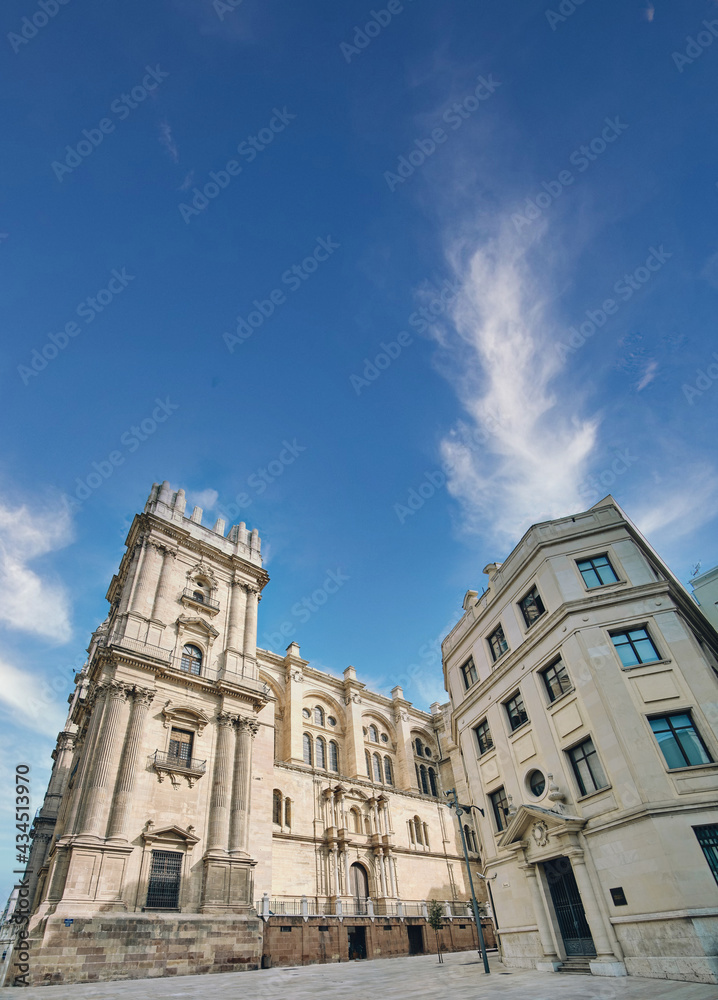 The Cathedral of Malaga, Spain, was completed in 1782. It is one of the largest cathedrals in the country and is located in the center of the city. Side view with lovely blue sky with clouds The Cathedral of Malaga, Spain, was completed in 1782. It is one of the largest cathedrals in the country and is located in the center of the city. Side view with lovely blue sky with clouds