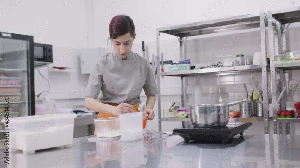 A bright girl cooks sweet dishes at a small production facility A bright girl cooks sweet dishes at a small production facility