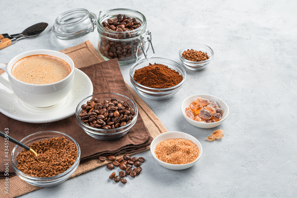 Coffee cup and cups with grain, instant and ground coffee on a gray background.