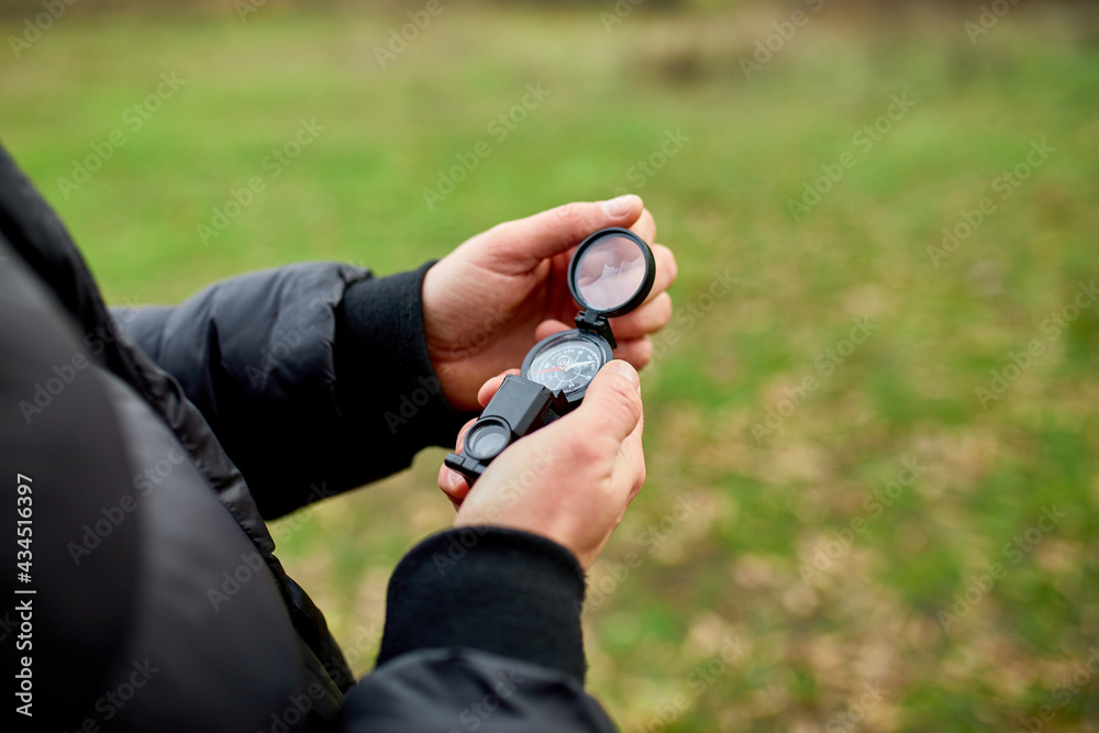 Close up of hand Traveler man with compass on a background of mountains of nature