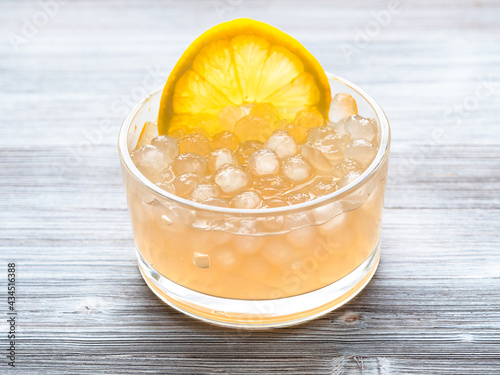 tapioca balls with lemon slice in bowl on gray photo