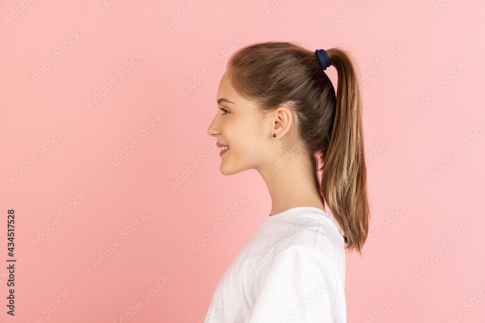 Caucasian young woman's portrait isolated over pink studio background with copyspace