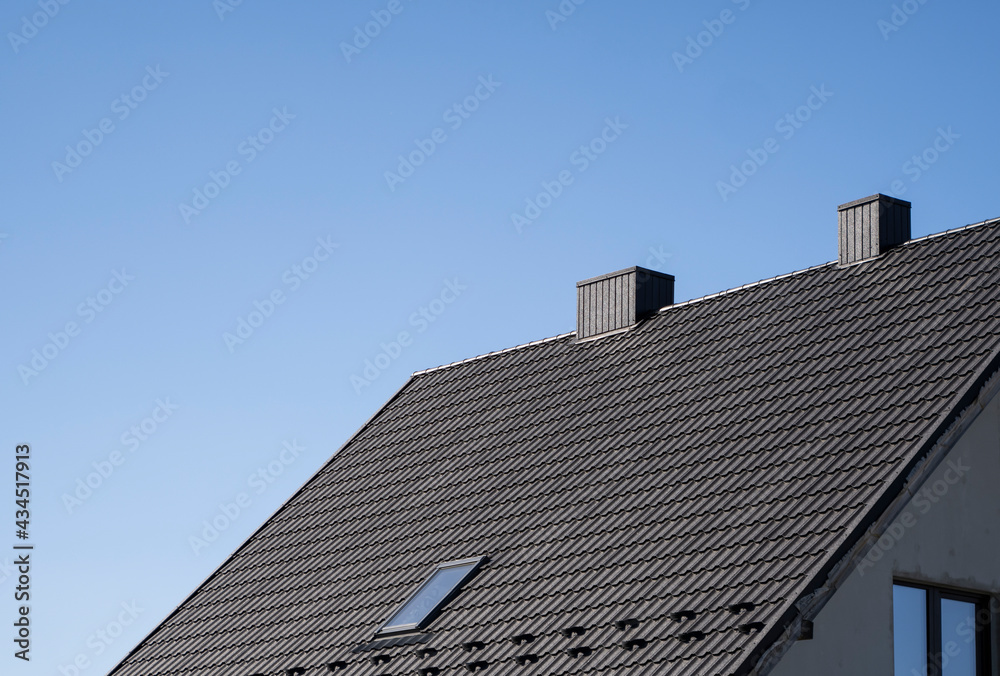 Brown corrugated metal profile roof installed on a modern house. The roof of corrugated sheet. Roofing of metal profile wavy shape. Modern roof made of metal. Metal roofing. Brown corrugated metal profile roof installed on a modern house. The roof of corrugated sheet. Roofing of metal profile wavy shape. Modern roof made of metal. Metal roofing.