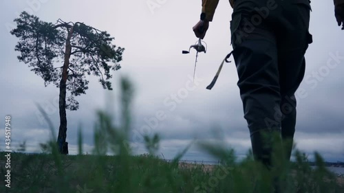 Man going to fishing. Walking with fishing rod. Leisure activity. Slow motion