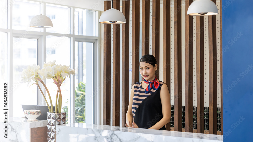 Young Asian female receptionist with confidence standing in arm crossed ...