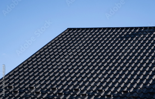 Grey corrugated metal profile roof installed on a modern house. The roof of corrugated sheet. Roofing of metal profile wavy shape. Modern roof made of metal. Metal roofing.