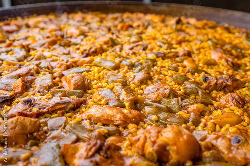 Valencian paella made of rice, chicken, rabbit and vegetables. Close up shot. photo